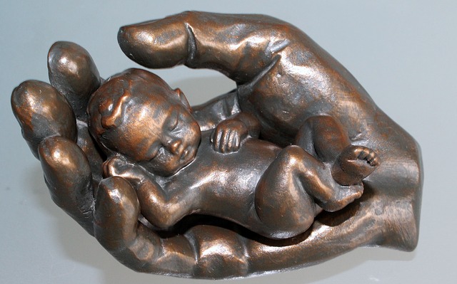 copper statue of child inside the palm